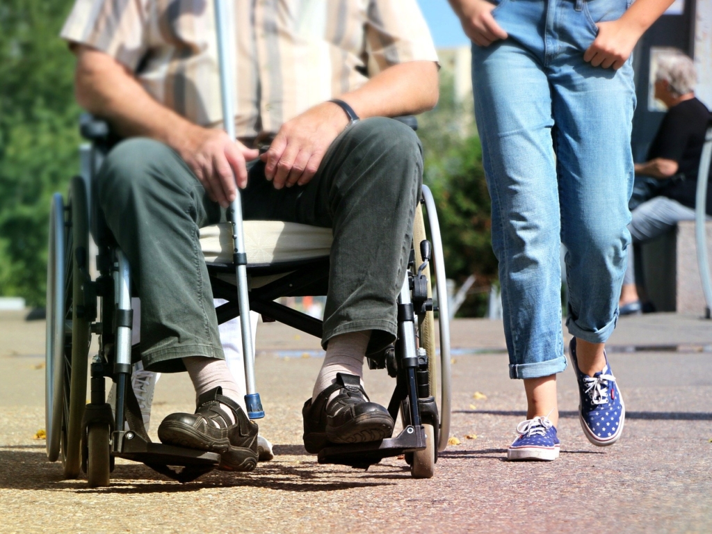 Gast im Rollstuhl mit ehrenamtlicher Helferin